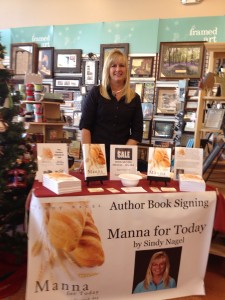 A woman standing behind a table with books on it.